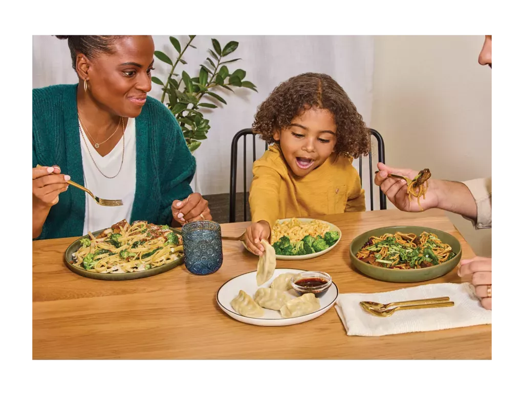 Family enjoying Noodles &amp; Company at a dinner table.