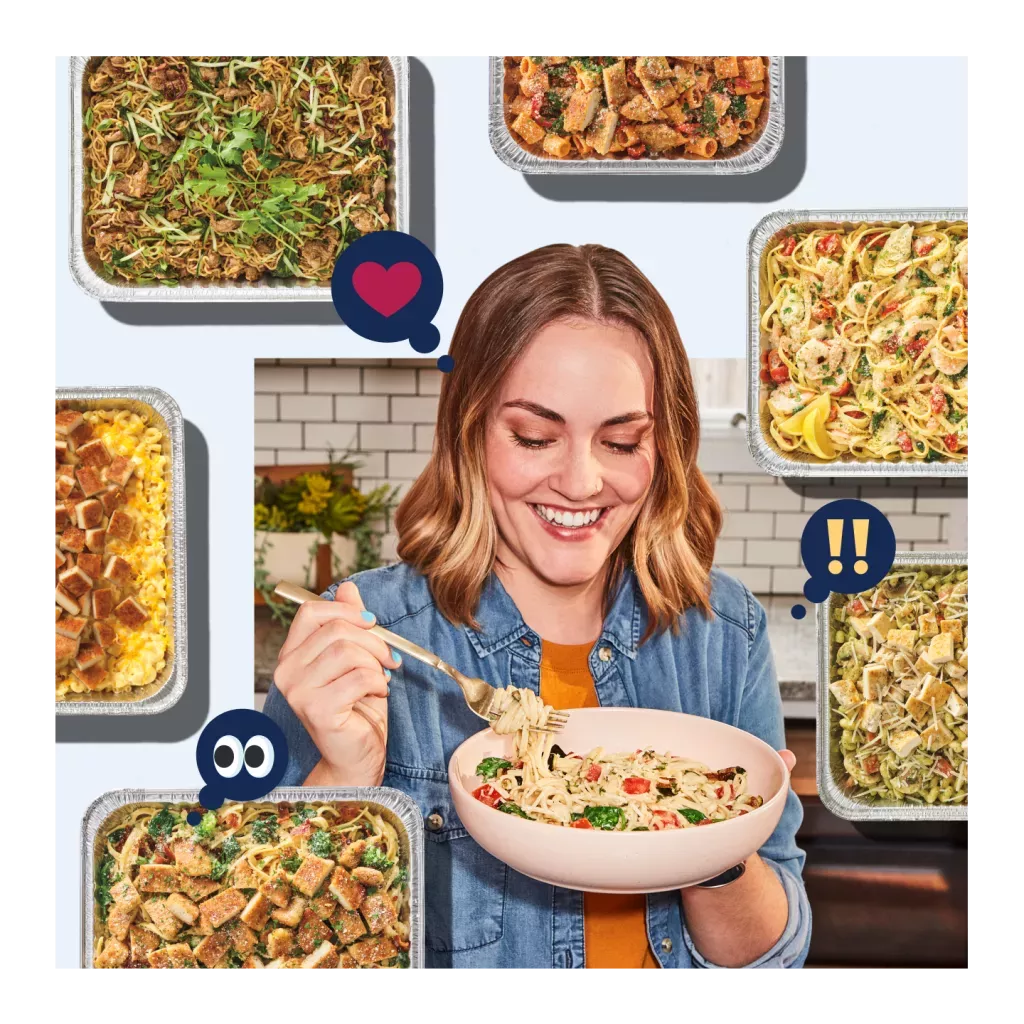 Noodles &amp; Company customer enjoying a bowl of noodles with catering pans decorating the background.