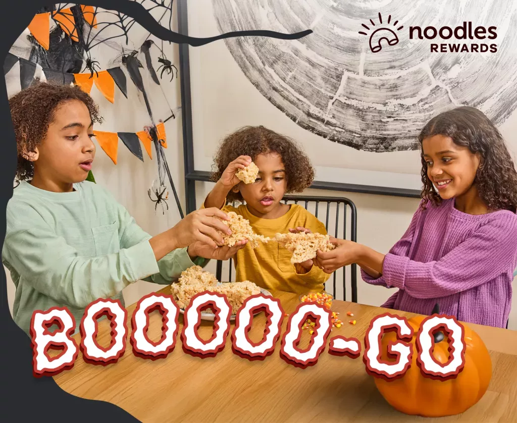 Noodles Rewards Logo. BOOOOO-GO. Children sharing a Crispy at a table.