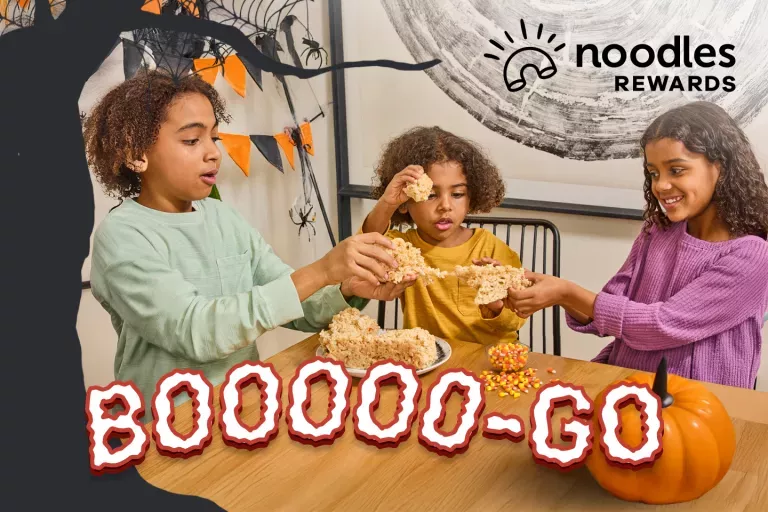Noodles Rewards Logo. BOOOOO-GO. Children sharing a Crispy at a table.