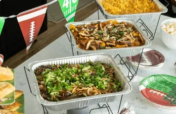 Noodles Catering spread with football flags and themed plates.