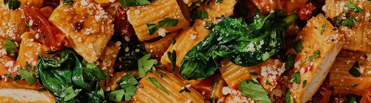 Close up image of rigatoni rosa with parmesan encrusted chicken