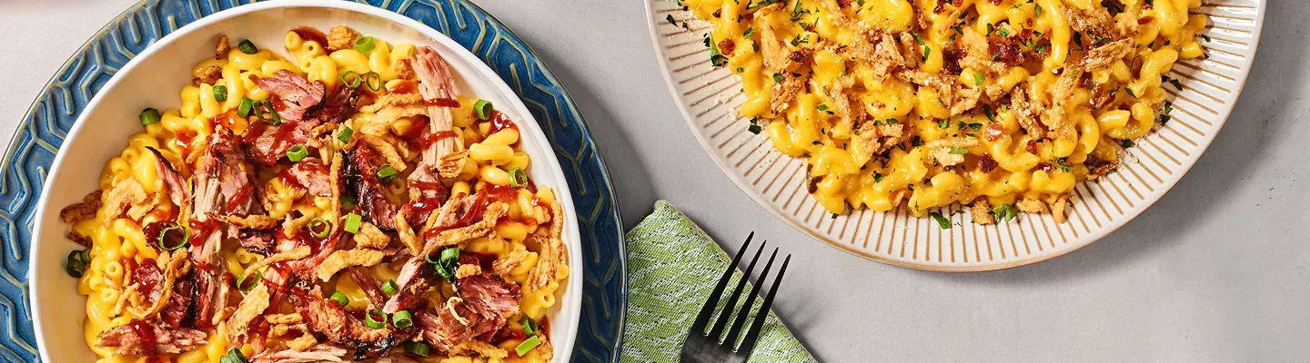 Pulled Pork BBQ Mac and Cheese with a fork, and Garlic Bacon Crunch Mac